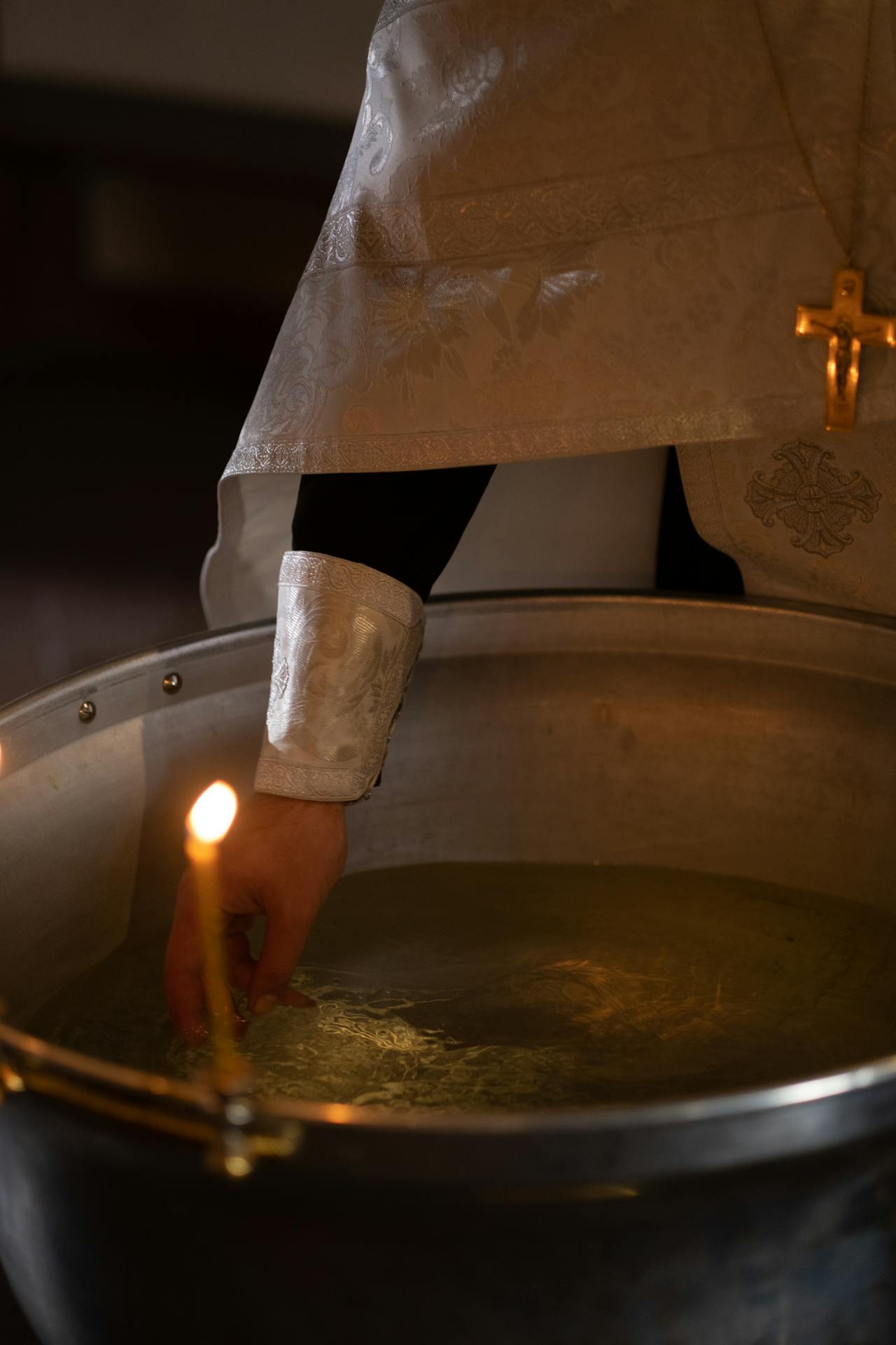 A priest preparing the holy water for a baptism