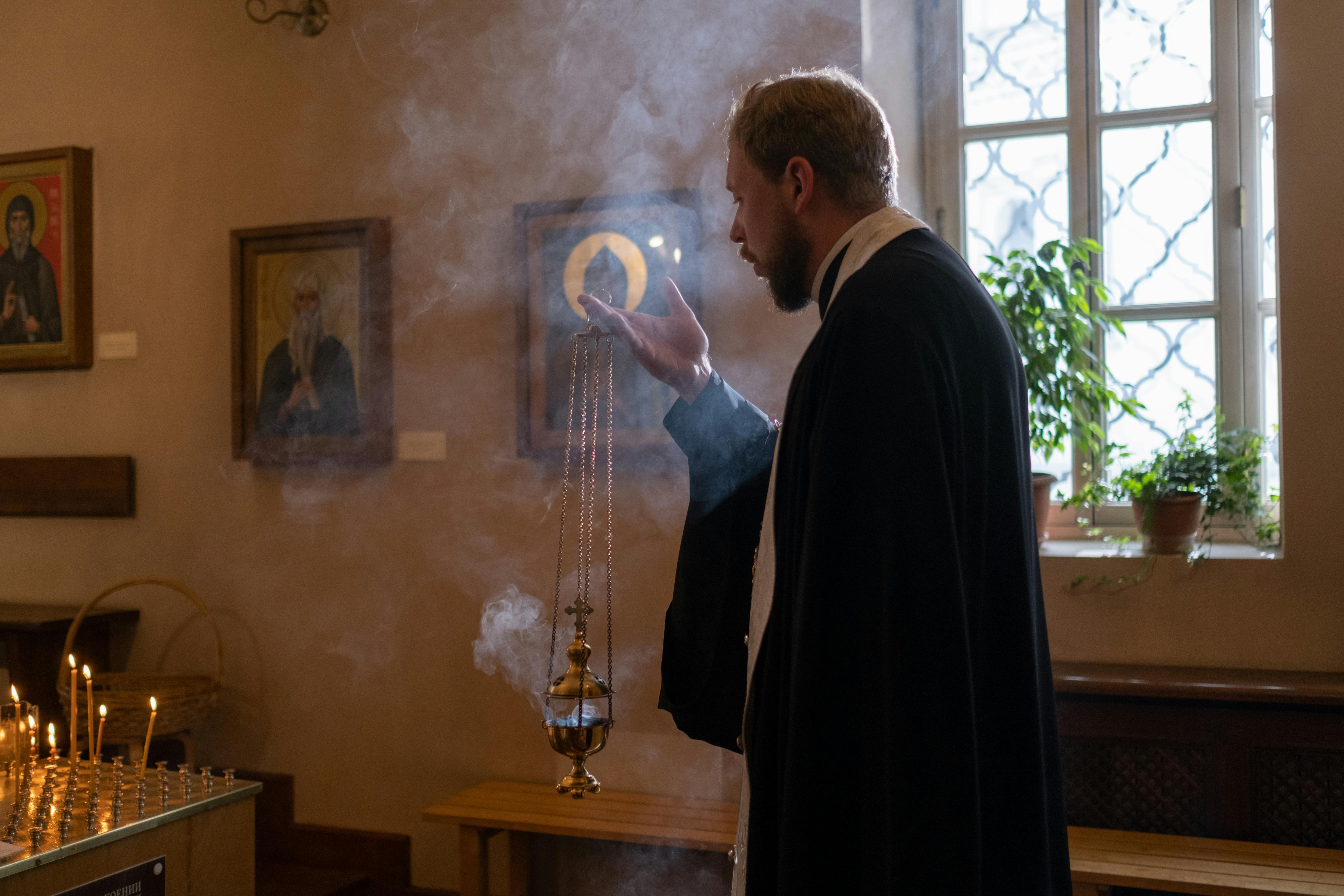 A priest waving incense in a church